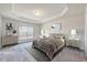 Staged main bedroom with a decorative trey ceiling, bedside tables, lamps, and matching dressers at 3162 Retama Run # 231, Apex, NC 27562
