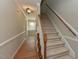 Inviting hallway with hardwood flooring leading to a carpeted staircase with wood railings at 3313 Ventura Cir, Wake Forest, NC 27587