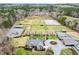 Stunning aerial view of an estate with horse pastures, riding arena, and well-manicured grounds at 3417 Pea Ridge Rd, New Hill, NC 27562