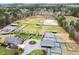 Aerial view of estate featuring home, garage, paddocks, arena, and barns at 3417 Pea Ridge Rd, New Hill, NC 27562