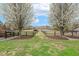 A symmetrical view of the backyard framed by flowering trees, leading to a fenced pasture area at 3417 Pea Ridge Rd, New Hill, NC 27562
