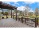 Spacious backyard with a covered porch, wooden railing, a sprawling yard, and white blossoming trees at 3417 Pea Ridge Rd, New Hill, NC 27562
