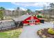 Aerial shot of a beautiful red barn with surrounding gravel driveway and landscaped area at 3417 Pea Ridge Rd, New Hill, NC 27562