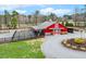 Spacious red barn with attached paddock and gravel driveway, perfect for equestrian enthusiasts at 3417 Pea Ridge Rd, New Hill, NC 27562