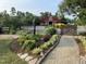 A picturesque red barn surrounded by a well-manicured garden and a charming brick path at 3417 Pea Ridge Rd, New Hill, NC 27562