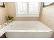 Clean, bright bathtub with tile surround and a plant on the corner at 3417 Pea Ridge Rd, New Hill, NC 27562