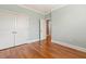 Spacious bedroom featuring hardwood floors, light blue walls, and white trim at 3417 Pea Ridge Rd, New Hill, NC 27562
