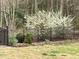 Charming landscaped yard with mature tree, iron fence, and manicured mulch at 3417 Pea Ridge Rd, New Hill, NC 27562