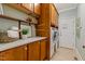 Laundry room with wooden cabinets, open shelving, stone countertops, and front load washer and dryer at 3417 Pea Ridge Rd, New Hill, NC 27562