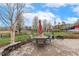Landscaped backyard featuring a stone patio with outdoor seating, blooming trees, and a fenced-in lawn at 3417 Pea Ridge Rd, New Hill, NC 27562