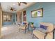 Comfortable sunroom with bright blue walls, tile floors, ceiling fans, and cozy seating at 3417 Pea Ridge Rd, New Hill, NC 27562