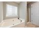 Bright bathroom showcasing a large soaking tub beneath a unique glass block window at 345 Anterbury Dr, Apex, NC 27502