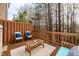 Relaxing deck with blue cushioned chairs, coffee table, and wooded view, offering a comfortable outdoor retreat at 345 Anterbury Dr, Apex, NC 27502