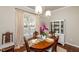 Bright dining room showcasing a wood table with seating for six next to a china cabinet and large window at 345 Anterbury Dr, Apex, NC 27502