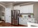 Spacious kitchen with stainless steel refrigerator, white cabinets and view to entry door at 345 Anterbury Dr, Apex, NC 27502