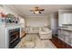 Open living room featuring a fireplace, plush sofa, and modern barstool seating to an open kitchen at 345 Anterbury Dr, Apex, NC 27502