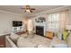 Cozy living room features a fireplace, plush sofa, and glass doors leading to the outside at 345 Anterbury Dr, Apex, NC 27502
