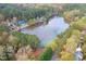 Scenic aerial view of a lake with a house nestled among the trees, offering a peaceful retreat at 4117 Olde Coach Rd, Durham, NC 27707
