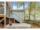 View of a gray back deck and stairs leading to the second story of a house with muted green siding at 4117 Olde Coach Rd, Durham, NC 27707