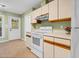 Galley-style kitchen with white appliances, wood trim, and an outdoor view at 4117 Olde Coach Rd, Durham, NC 27707