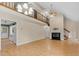 Bright living room showcasing a fireplace, wood floors, stairs and balcony overlooking the space at 4117 Olde Coach Rd, Durham, NC 27707