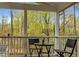 Covered porch showing a seating area, railing, and view of fall foliage at 4117 Olde Coach Rd, Durham, NC 27707