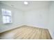 Inviting bedroom with wood-look flooring, a window, and a flush-mount light at 423 E Rockspring St, Henderson, NC 27536