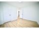 Bedroom with hardwood floors, neutral walls, and open doorway to hall at 423 E Rockspring St, Henderson, NC 27536