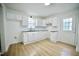 Bright kitchen features white cabinets, black countertops, stainless steel faucet, and wood-look flooring at 423 E Rockspring St, Henderson, NC 27536