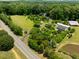 Aerial view of expansive property featuring fields, greenhouses, barn, pond, and main residence at 4811 New Sharon Church Rd, Hillsborough, NC 27278