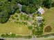 Estate aerial view featuring house, lush landscaping, pond, barns, and open fields at 4811 New Sharon Church Rd, Hillsborough, NC 27278
