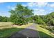 Long driveway surrounded by trees and lawn, showcasing an outdoor space with privacy at 4811 New Sharon Church Rd, Hillsborough, NC 27278