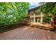 Back exterior of home with a brick facade, large windows, and a spacious wood deck at 4811 New Sharon Church Rd, Hillsborough, NC 27278