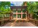 Back exterior with brick walls, large glass doors and windows, and wood deck with railing at 4811 New Sharon Church Rd, Hillsborough, NC 27278