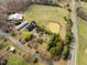 This aerial view showcases a sprawling property with a pond, farm buildings and agricultural potential at 4811 New Sharon Church Rd, Hillsborough, NC 27278