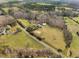 Expansive aerial view of a beautiful lot with mature trees, open pasture and a home at 4811 New Sharon Church Rd, Hillsborough, NC 27278