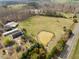 An aerial view displays the property featuring a pond, barn, greenhouses, and open acreage at 4811 New Sharon Church Rd, Hillsborough, NC 27278