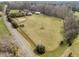 Aerial view of a large property featuring an open field and mature trees at 4811 New Sharon Church Rd, Hillsborough, NC 27278