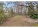 View of a tree-lined backyard featuring a wood fence and natural surroundings at 4811 New Sharon Church Rd, Hillsborough, NC 27278