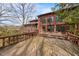 Large backyard with a wooden deck, brick exterior, and multiple windows at 4811 New Sharon Church Rd, Hillsborough, NC 27278