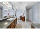Bright bathroom featuring double sinks, granite countertops, and wood cabinets at 4811 New Sharon Church Rd, Hillsborough, NC 27278