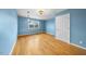 Bedroom featuring hardwood floors, blue walls, natural light and a white door at 4811 New Sharon Church Rd, Hillsborough, NC 27278