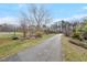 Scenic paved driveway leading up to the property with grassy and partially wooded areas at 4811 New Sharon Church Rd, Hillsborough, NC 27278
