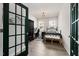 Charming bedroom with a black iron bed frame, decorative door and natural light from two windows at 508 Sweet Pine Ln, Knightdale, NC 27545