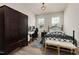 Bedroom with a black iron bed frame, dark wooden armoire, light-colored walls, and wooden floors at 508 Sweet Pine Ln, Knightdale, NC 27545