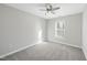 A well-lit bedroom features neutral walls, gray carpet, a window, and a ceiling fan with light fixture at 54 Silverleaf Dr, Wendell, NC 27591