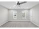 Cozy bedroom with neutral carpet, ceiling fan, and bright windows letting in natural light at 54 Silverleaf Dr, Wendell, NC 27591