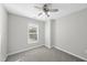 A well-lit bedroom features neutral walls, gray carpet, a window, and a ceiling fan with light fixture at 54 Silverleaf Dr, Wendell, NC 27591