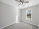 Bright bedroom featuring neutral walls, gray carpet, a window, and a ceiling fan with light fixture at 54 Silverleaf Dr, Wendell, NC 27591
