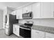 Modern kitchen featuring stainless steel appliances, granite countertops, and white cabinets at 54 Silverleaf Dr, Wendell, NC 27591